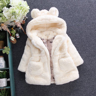 White fur-lined hooded coat on a dark background with decorative elements.
